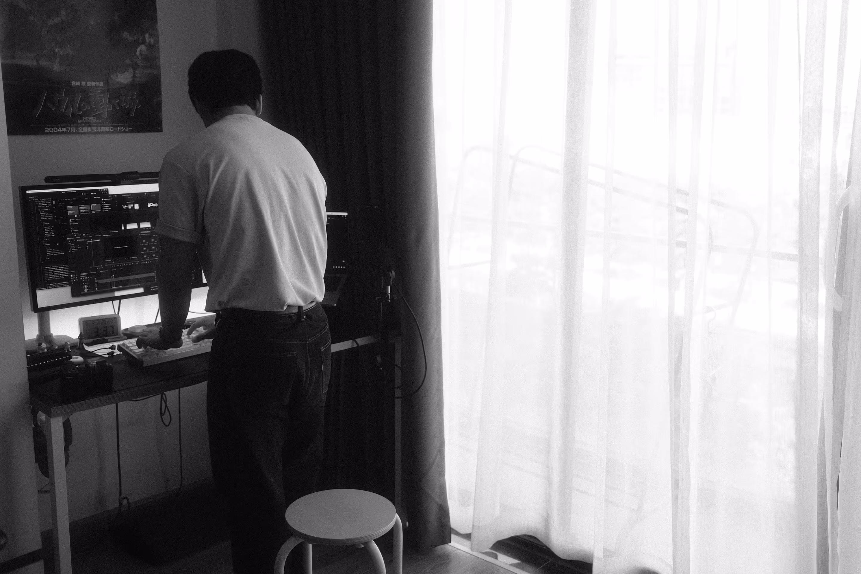 A black and white image of the founder of the studio, Huy, working at the desk.